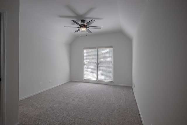 carpeted empty room with ceiling fan and vaulted ceiling