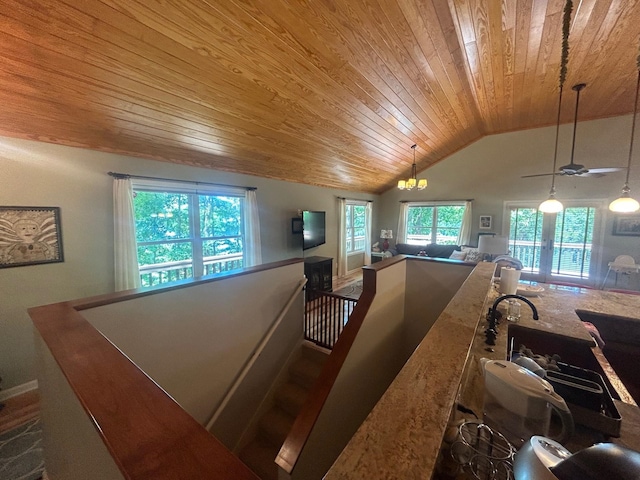 interior space featuring wood ceiling, lofted ceiling, ceiling fan with notable chandelier, and hanging light fixtures