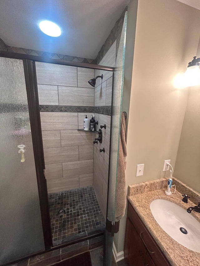 bathroom with a shower with door and vanity