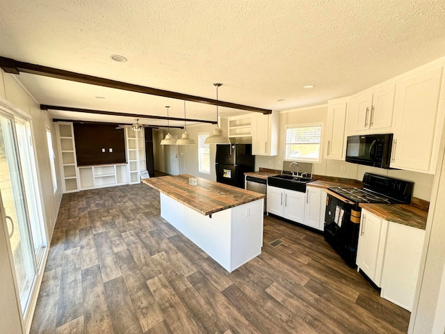 kitchen with pendant lighting, white cabinetry, black appliances, and wood counters