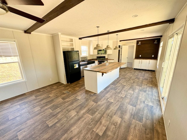 kitchen featuring black appliances, butcher block countertops, dark hardwood / wood-style flooring, hanging light fixtures, and a center island