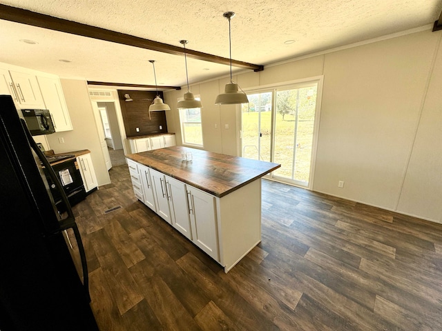 kitchen with butcher block counters, white cabinetry, a textured ceiling, hanging light fixtures, and a kitchen island