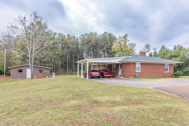 view of front of property with a front yard, an outbuilding, and a carport