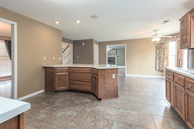 kitchen with kitchen peninsula, a textured ceiling, and ceiling fan