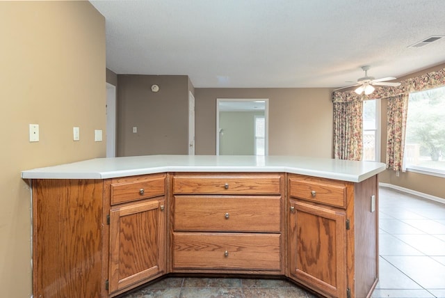 kitchen with tile patterned flooring, a textured ceiling, and ceiling fan