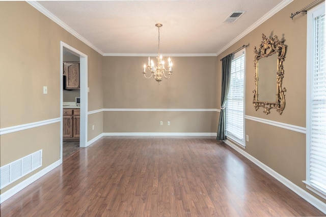 unfurnished room with a chandelier, crown molding, and dark hardwood / wood-style floors