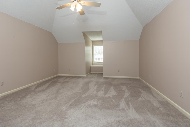 bonus room with vaulted ceiling, light carpet, and ceiling fan