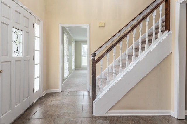 tiled entrance foyer with a healthy amount of sunlight