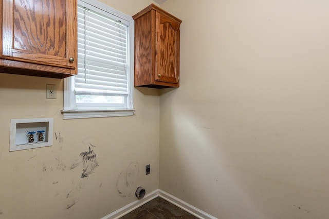 laundry room featuring hookup for a washing machine, electric dryer hookup, cabinets, and dark tile patterned flooring