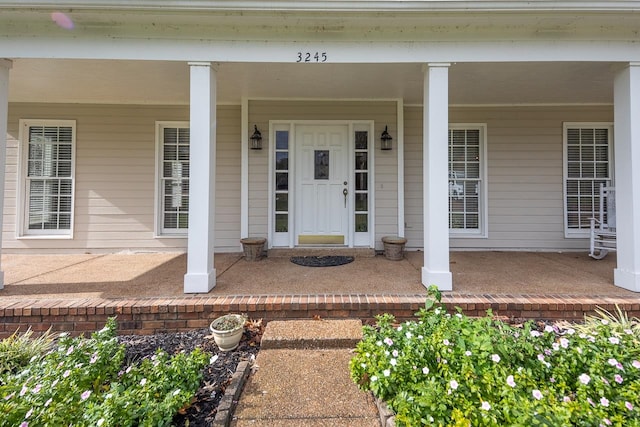 view of exterior entry featuring covered porch