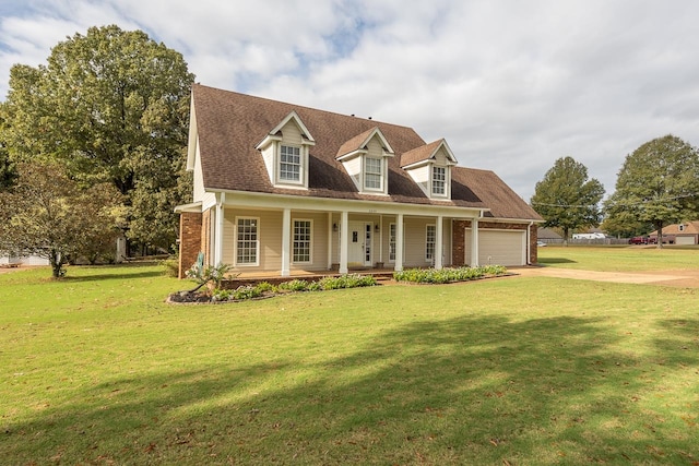 new england style home featuring covered porch, a front lawn, and a garage