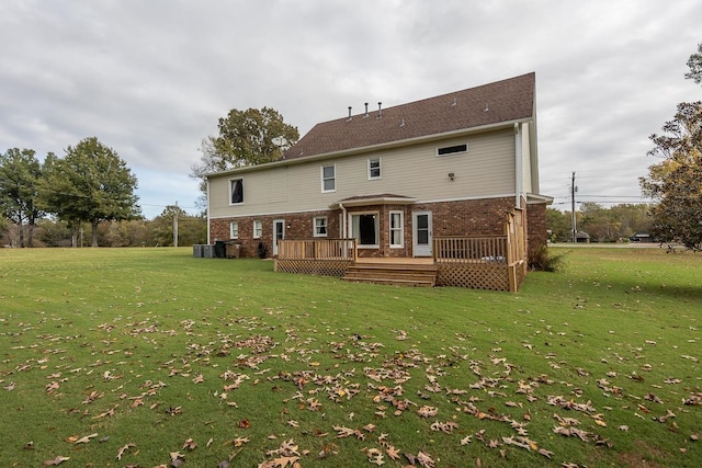 back of property with a deck and a lawn