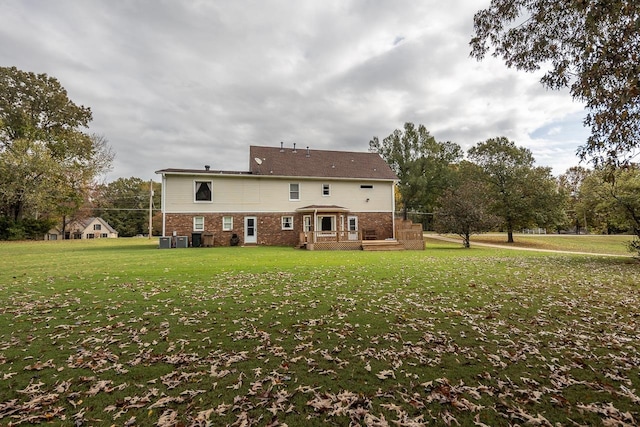 rear view of property with a deck and a yard