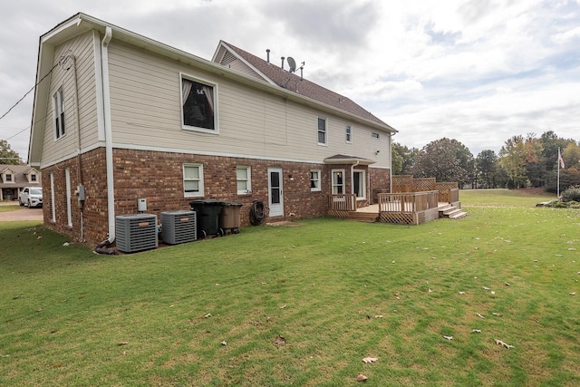 rear view of house featuring a wooden deck, a lawn, and central AC unit