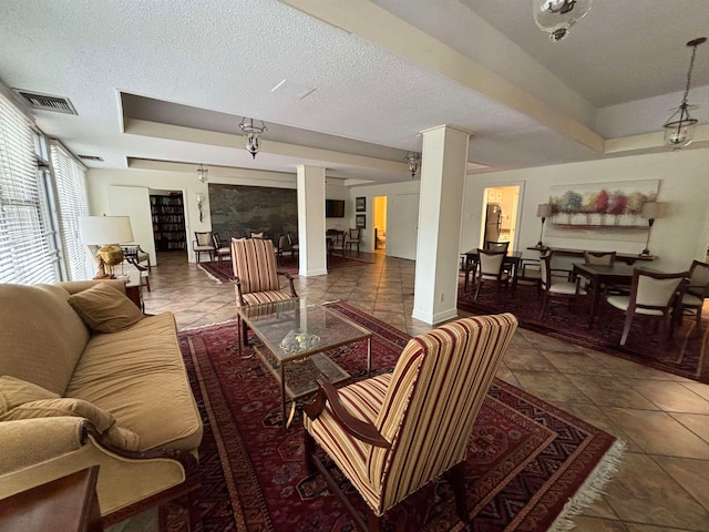 living room with a textured ceiling, a tray ceiling, and dark tile patterned flooring