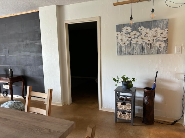 dining space featuring a textured ceiling and concrete flooring