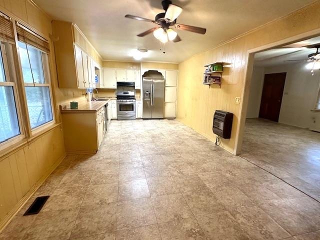 kitchen with sink, ceiling fan, appliances with stainless steel finishes, and heating unit