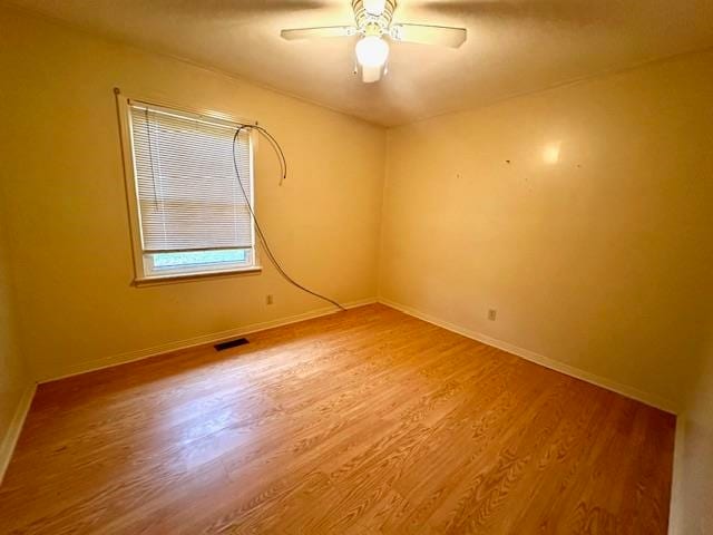 spare room featuring wood-type flooring and ceiling fan