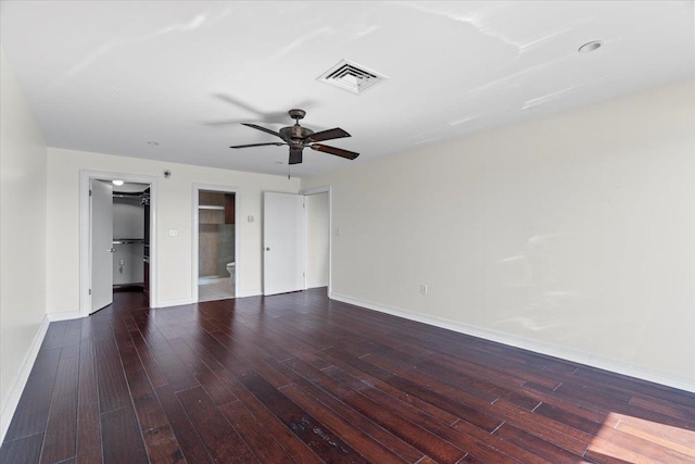 unfurnished bedroom with ceiling fan, a walk in closet, a closet, and dark hardwood / wood-style flooring