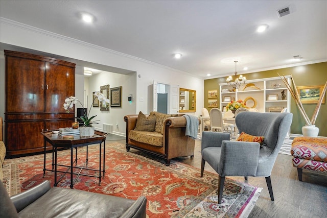 living room featuring light hardwood / wood-style flooring, crown molding, and a notable chandelier