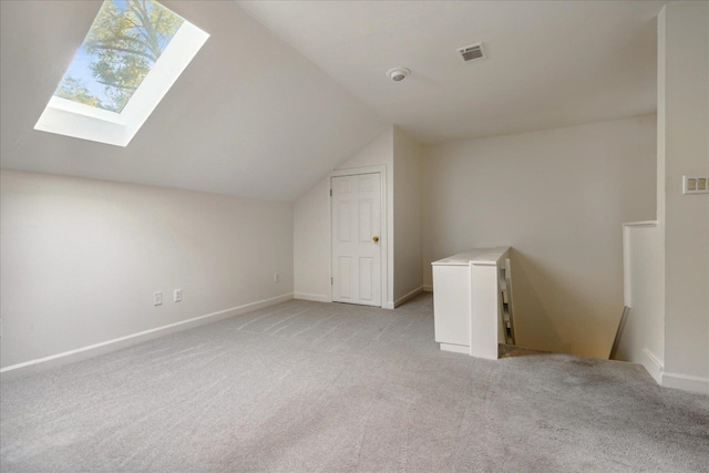 bonus room featuring light carpet and vaulted ceiling with skylight