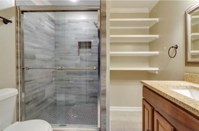 bathroom featuring a shower with door, toilet, tile patterned flooring, ornamental molding, and vanity