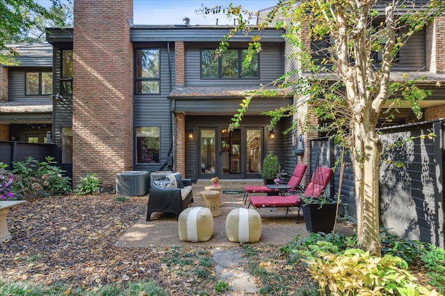 rear view of property with french doors, a patio area, and central AC