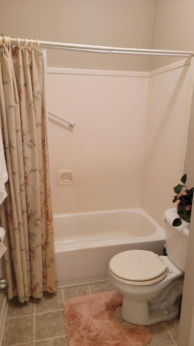 bathroom with toilet, shower / tub combo, and tile patterned flooring