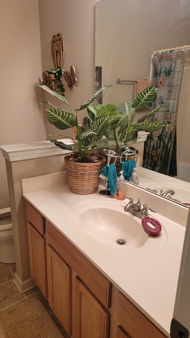 bathroom with vanity, tile patterned flooring, and toilet