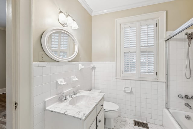 full bathroom featuring tile patterned floors, toilet, tiled shower / bath, ornamental molding, and vanity