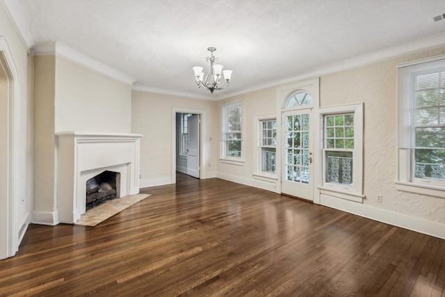 unfurnished living room with a chandelier, dark hardwood / wood-style floors, and a healthy amount of sunlight