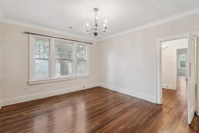 unfurnished room featuring a chandelier, crown molding, and dark hardwood / wood-style flooring