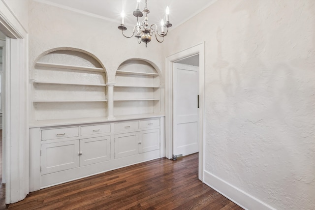 unfurnished dining area featuring dark hardwood / wood-style floors, a chandelier, and built in shelves