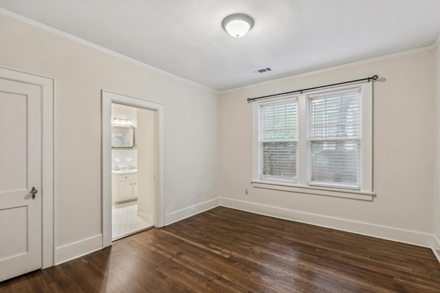 unfurnished bedroom featuring ensuite bath, crown molding, and dark hardwood / wood-style floors