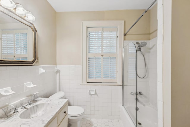 full bathroom featuring toilet, tile walls, tiled shower / bath, vanity, and tile patterned flooring