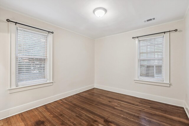 empty room featuring crown molding and dark wood-type flooring