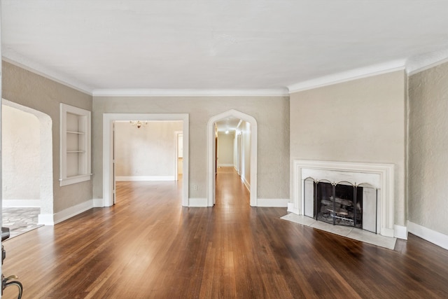 unfurnished living room featuring crown molding, dark hardwood / wood-style flooring, and built in shelves