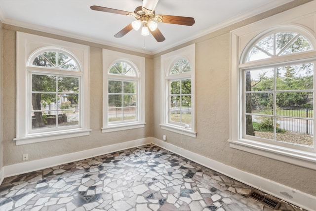 unfurnished sunroom featuring ceiling fan