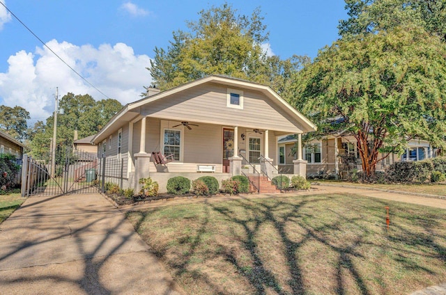 bungalow-style home with covered porch, ceiling fan, a front yard, and central air condition unit