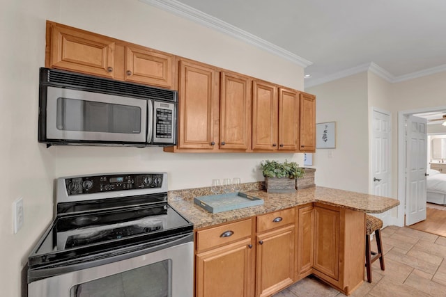 kitchen with a peninsula, a breakfast bar area, crown molding, appliances with stainless steel finishes, and light stone counters