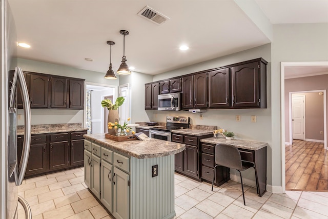 kitchen with stainless steel appliances, dark brown cabinetry, a center island, and hanging light fixtures