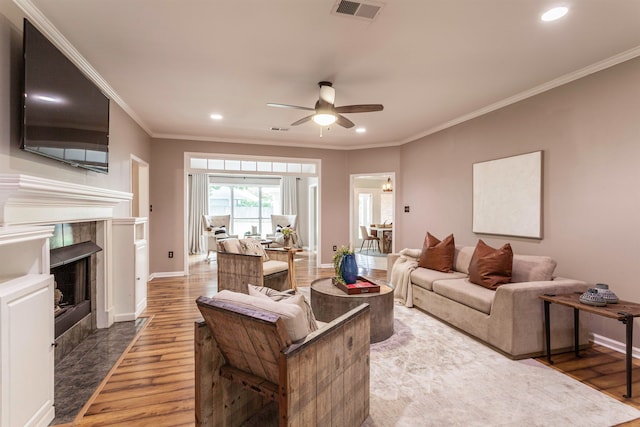 living room with ornamental molding, hardwood / wood-style floors, and a tile fireplace