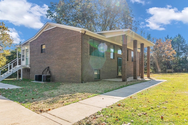 view of home's exterior with a lawn and central AC unit