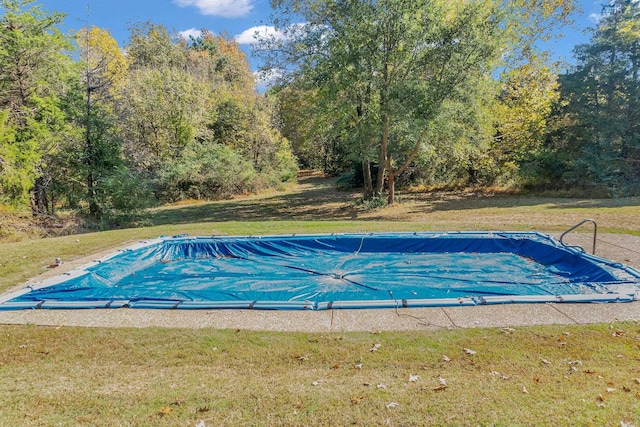 view of swimming pool with a lawn