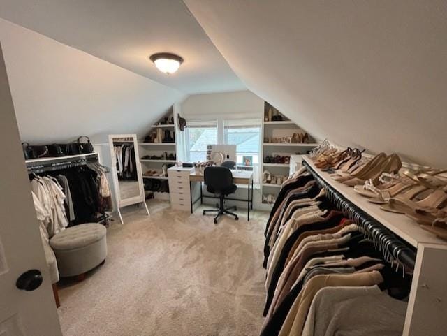 walk in closet featuring light carpet and lofted ceiling