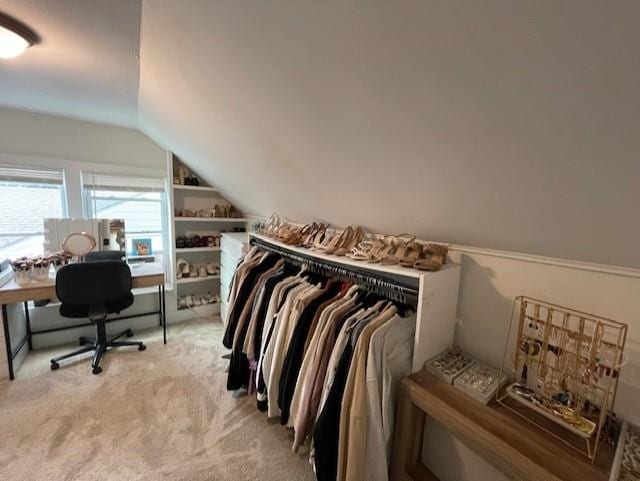 spacious closet with vaulted ceiling and light colored carpet