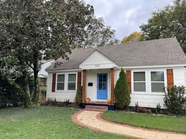 bungalow-style home with a front yard