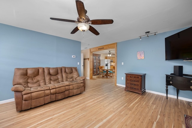 living room with ceiling fan and light wood-type flooring