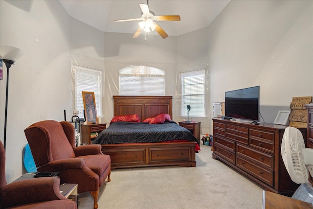 bedroom with light colored carpet, high vaulted ceiling, and ceiling fan