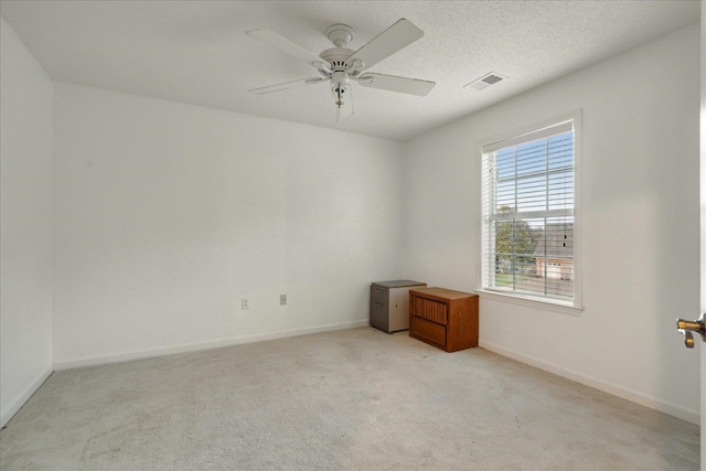 empty room with ceiling fan, light colored carpet, and a wealth of natural light